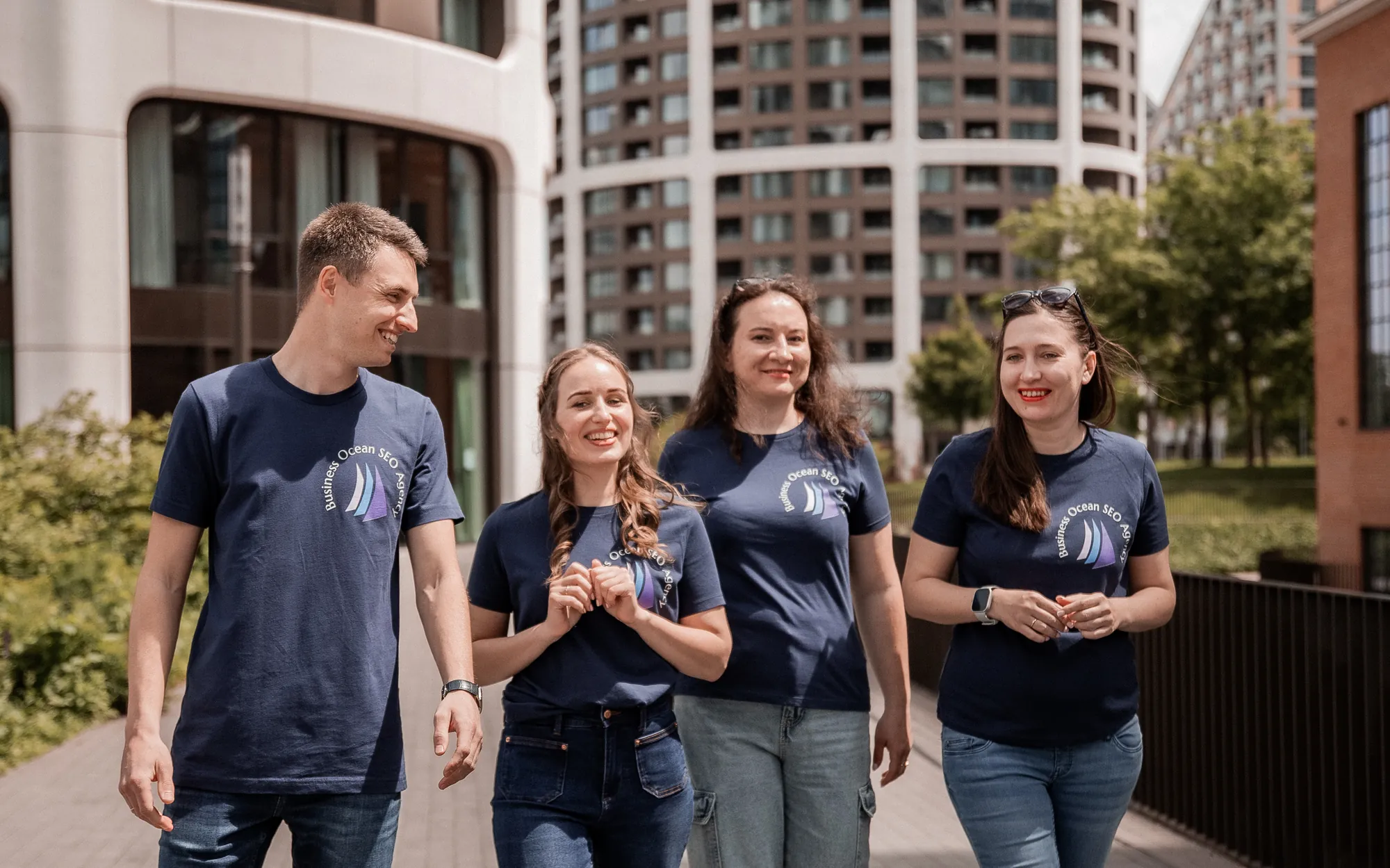 The Business Ocean team walking through a modern city block in branded navy t‑shirts
