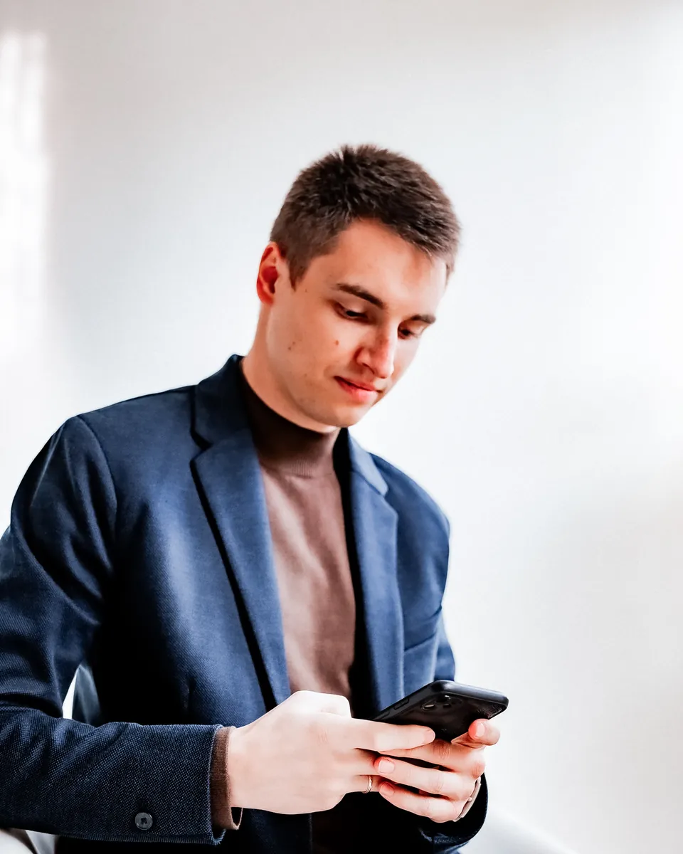 Artem reviewing a client's Instagram feed on a phone in the studio