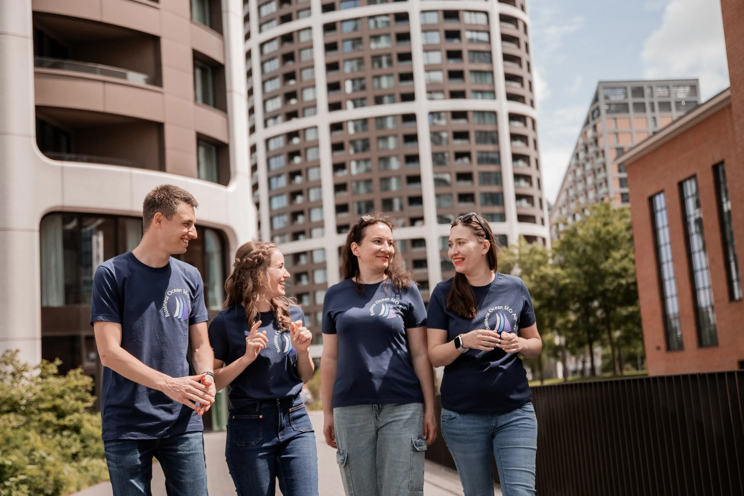 The Business Ocean team walking through a modern city block in branded navy t‑shirts